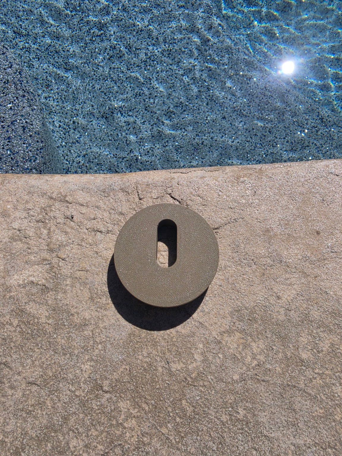 MRKSENS replacement deck jet cover plate shown beside a swimming pool