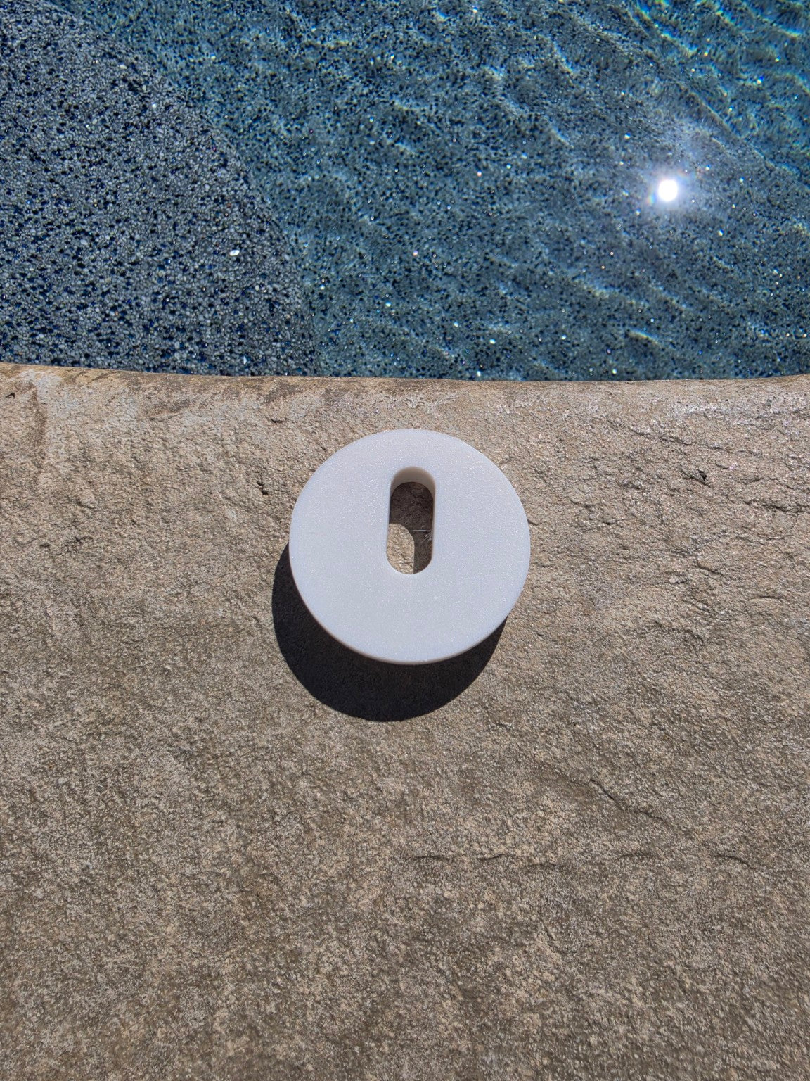 MRKSENS replacement deck jet cover plate photographed on a pool deck
